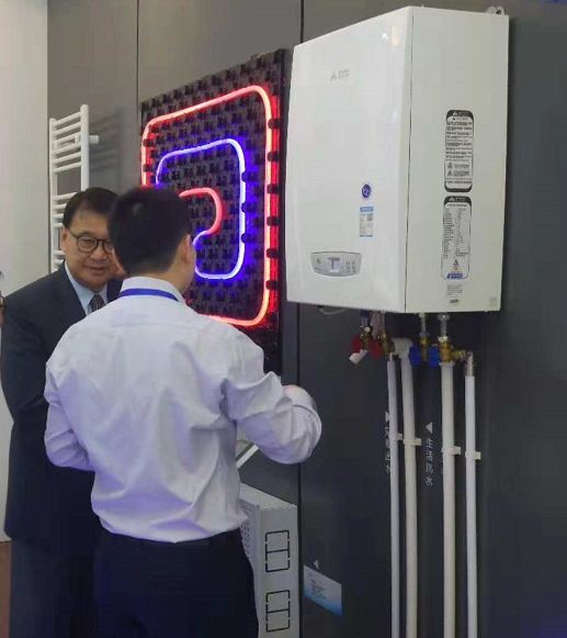 15447068049274.png 港華燃?xì)鈽I(yè)務(wù)人員為參觀者講解艾萊卡冷凝壁掛爐技術(shù)特點(diǎn).png